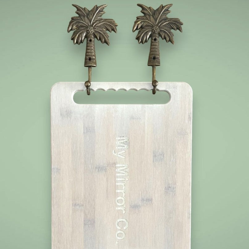 Two palm tree hooks in the antique finish creates a simple space for your bamboo mirrors.