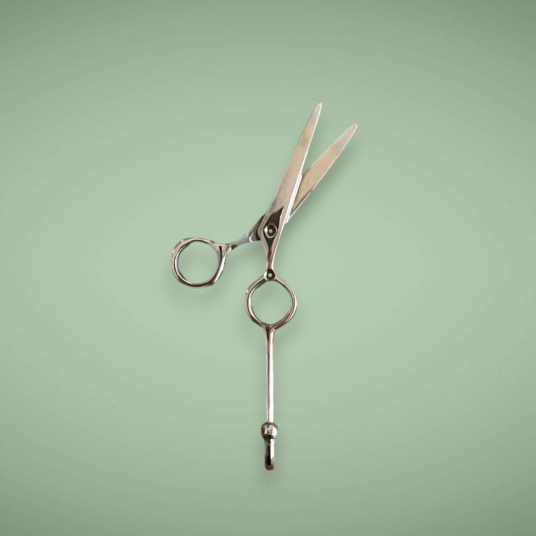 Our silver brass hook in the shape of scissors is perfect to hang your hair equipment on.