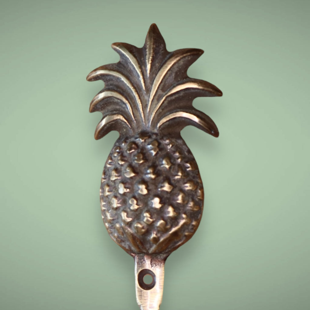 Antique brass hook in a pineapple design.