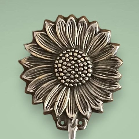 The brass hook in an antique sunflower design.